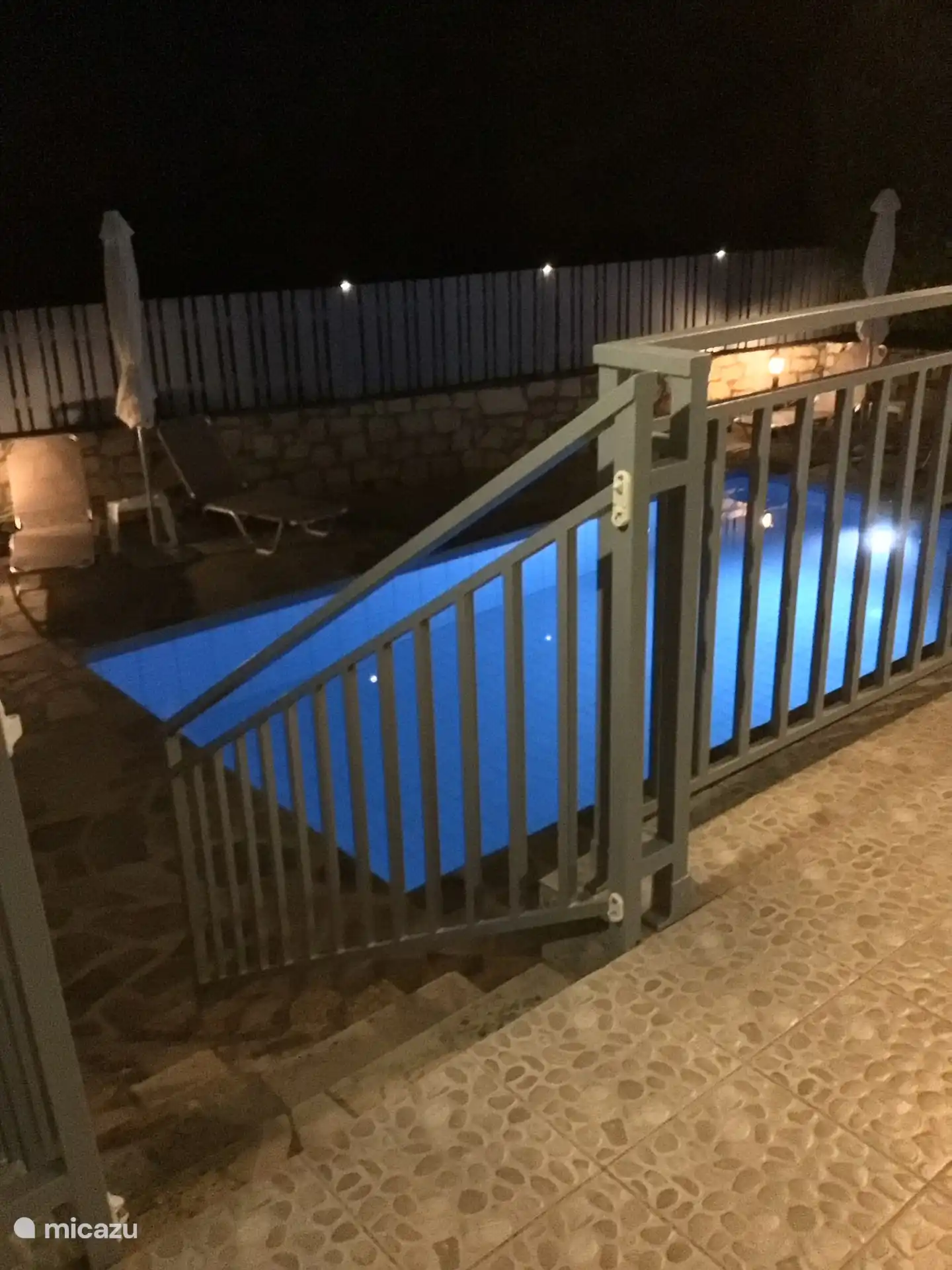 View of illuminated swimming pool from the terrace.