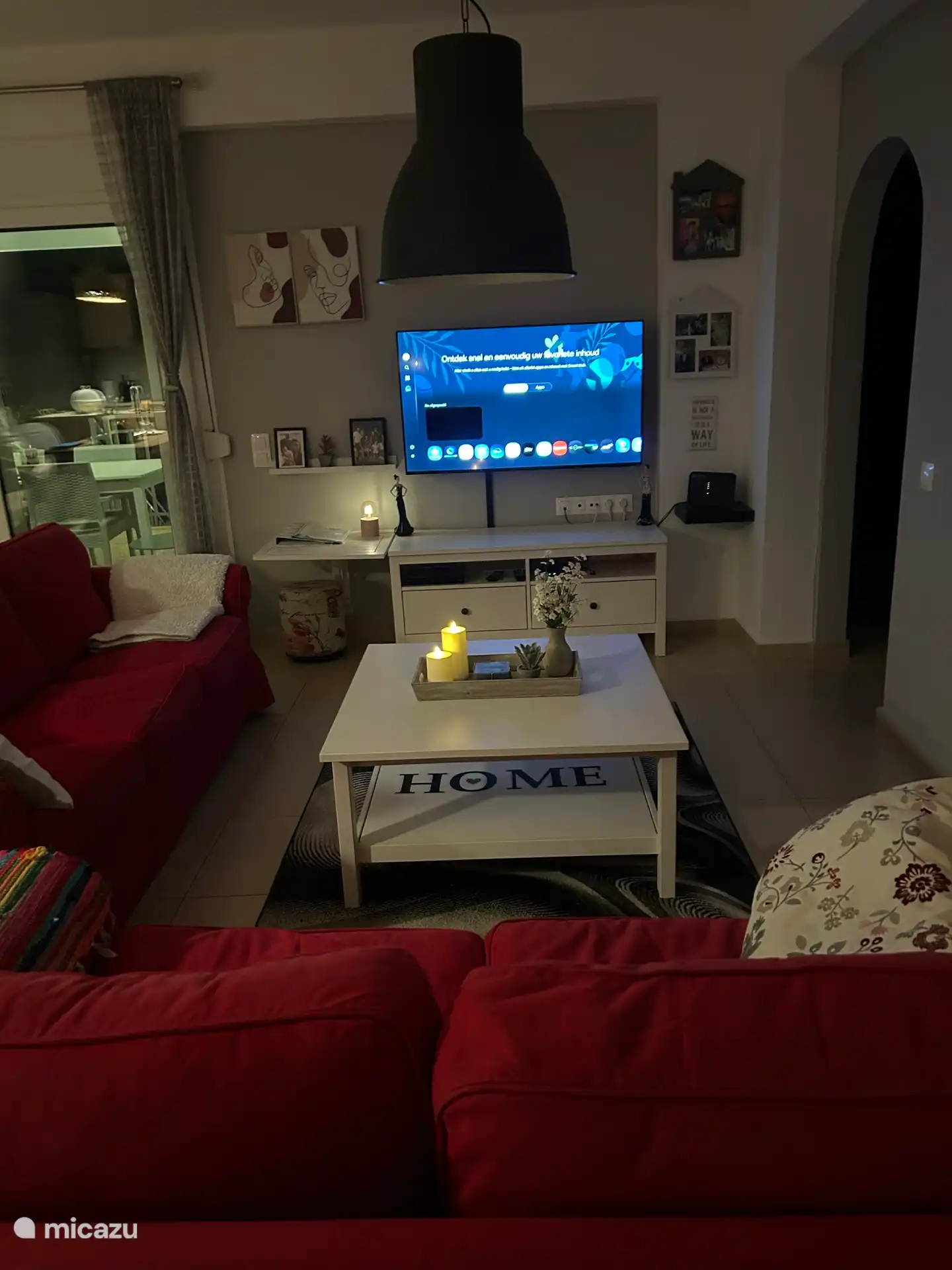 Zitgedeelte woonkamer met twee- en driezitsbankstel, salontafel, tv- meubel en grote 50” Samsung smart tv.