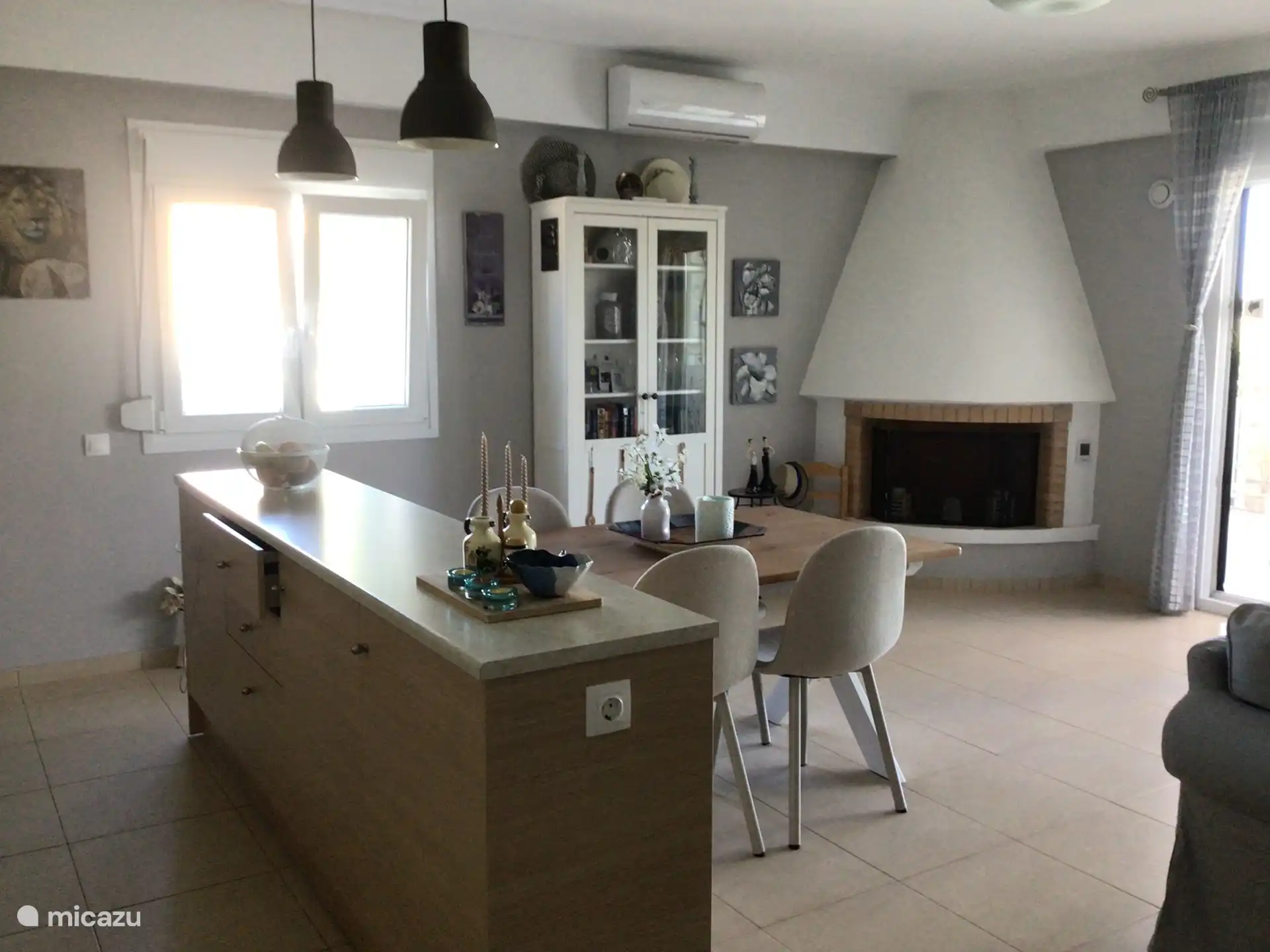 Fireplace, display cabinet and dining area seen from the kitchen.