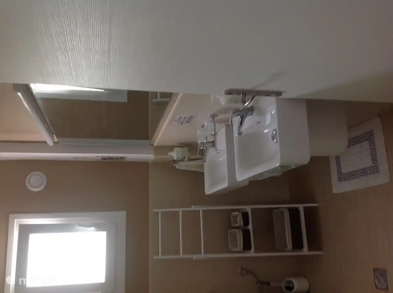 Bathroom view upon entry, with two sinks, toilet and walk-in shower