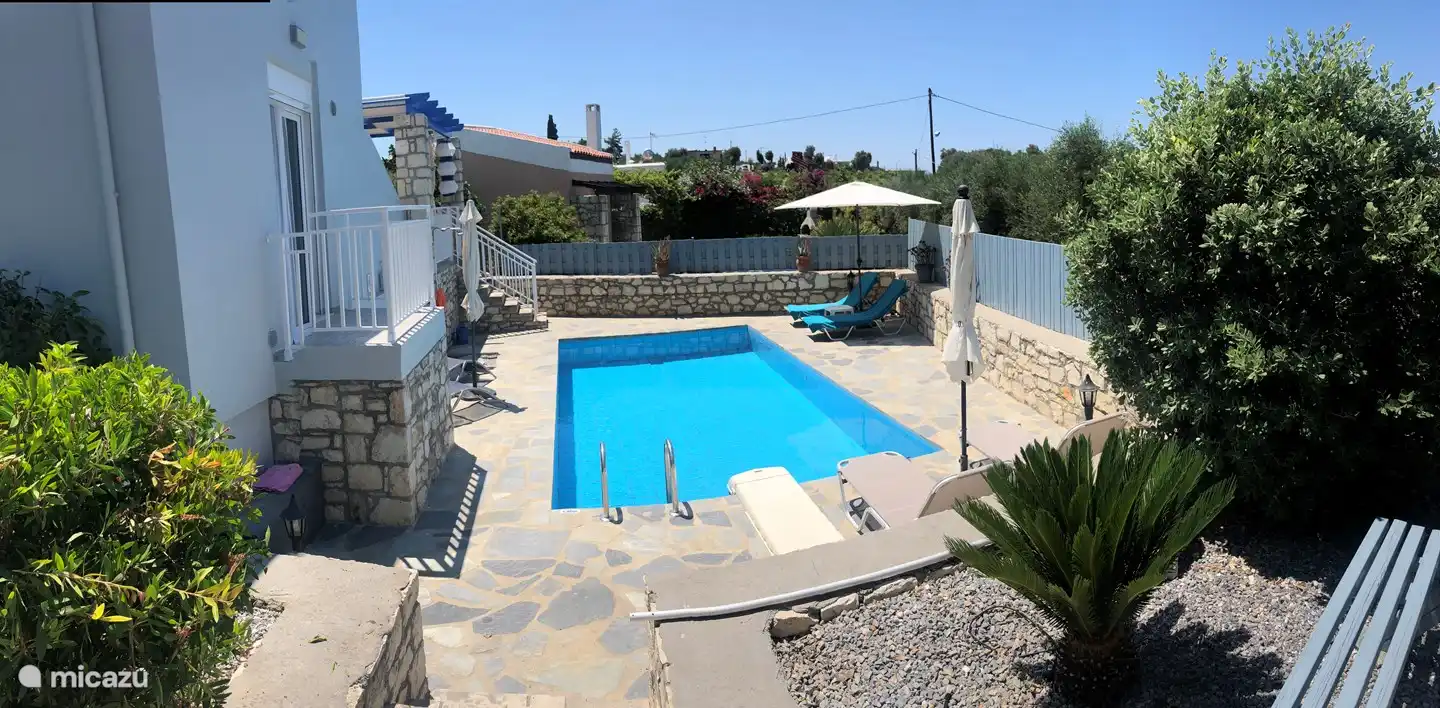 Swimming pool seen from the slightly higher bbq terrace with large side garden