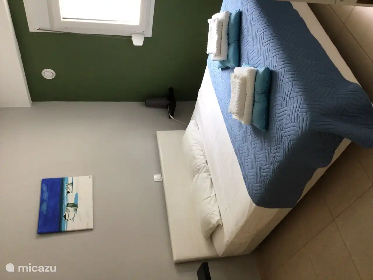 Bedroom 2 has a large opening window with mosquito net and shutter.