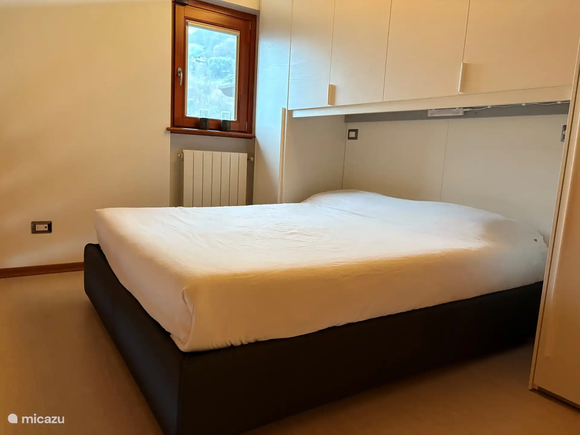 Dormitorio de los padres con mucho espacio de almacenamiento, cama doble, aire acondicionado privado y vistas despejadas de la montaña y el lago