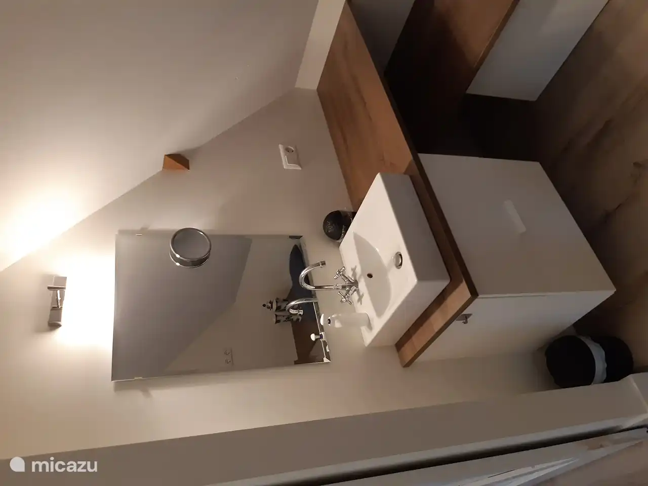 Foto des Waschbeckens mit Spiegel im Schlafzimmer.