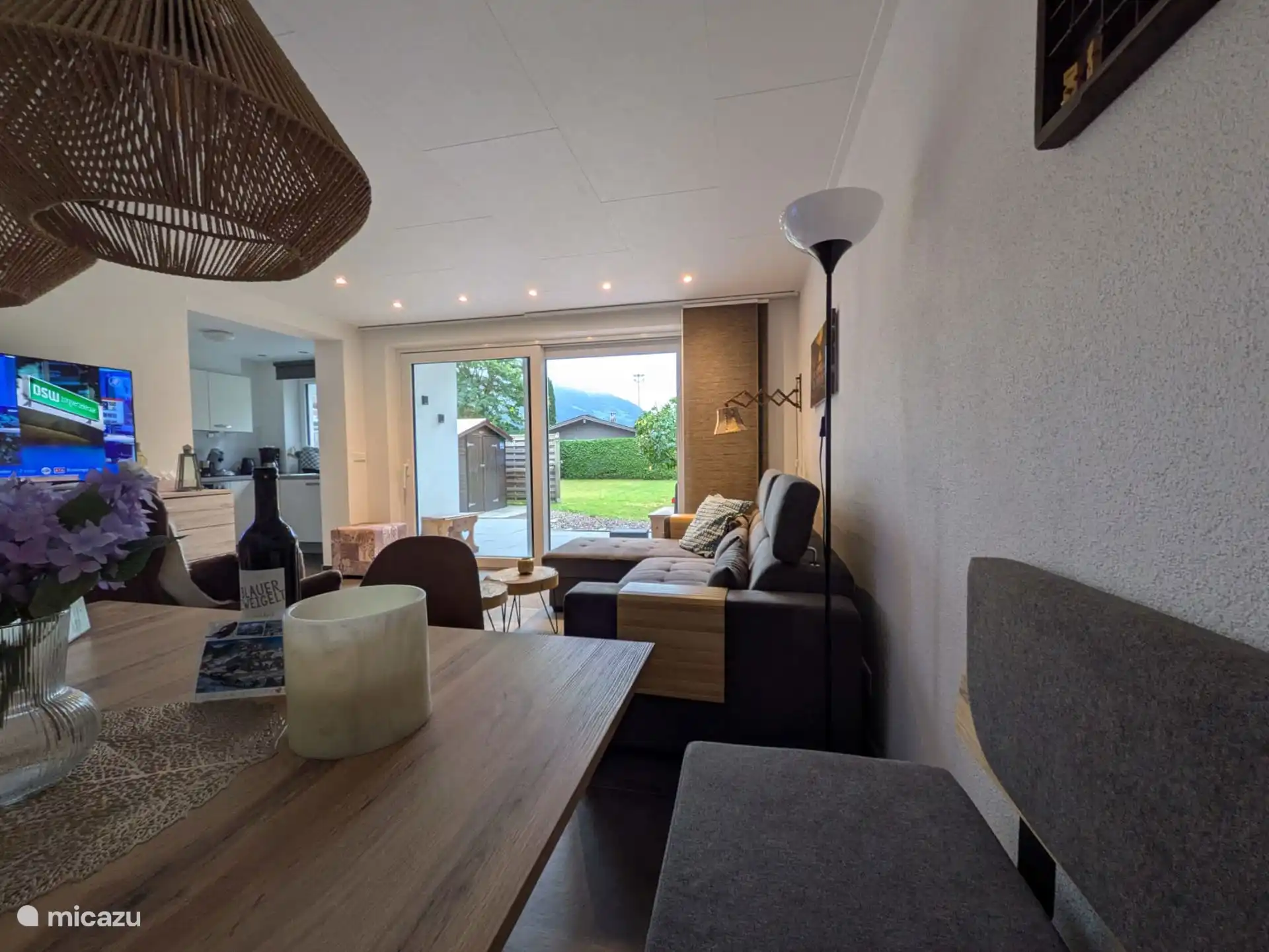 Desde el sofá de la esquina de la mesa del comedor con vistas al jardín y a las montañas 