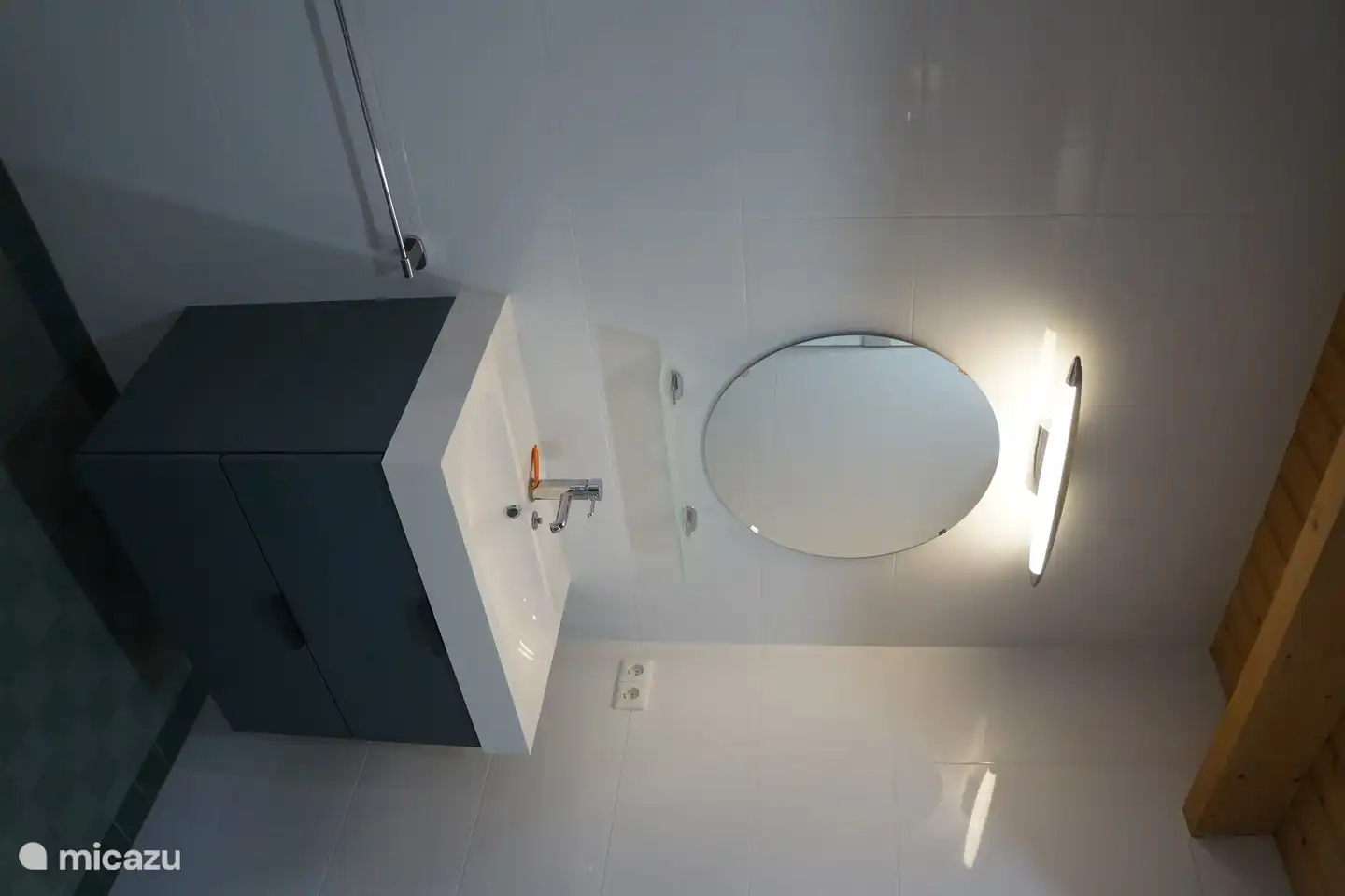 Badezimmer mit Dusche, Waschbecken, Toilette und Waschmaschine.