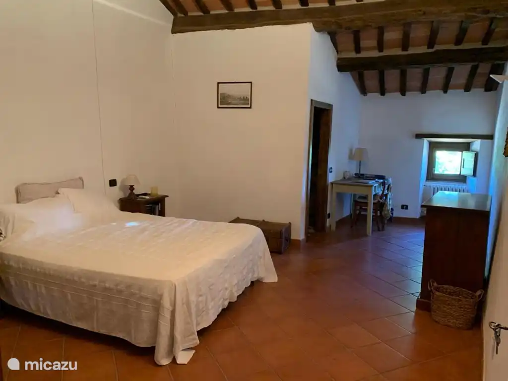 Bedroom 4 facing east, with a double bed (180 x 200 cm), cot and propeller fan on ceiling. Private bathroom