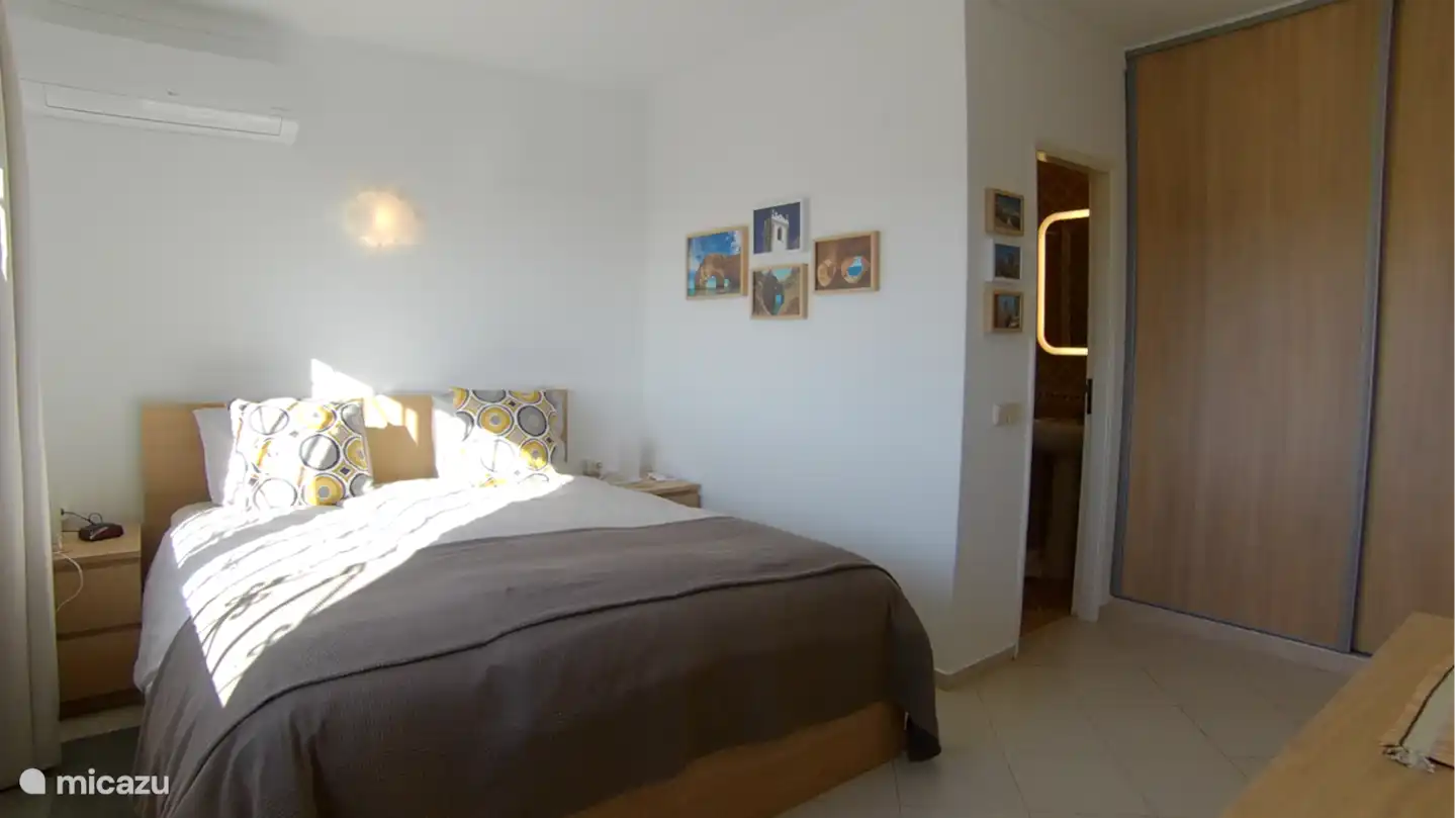 Salle de bain intégrée à la chambre des maîtres. Une partie de l'armoire visible