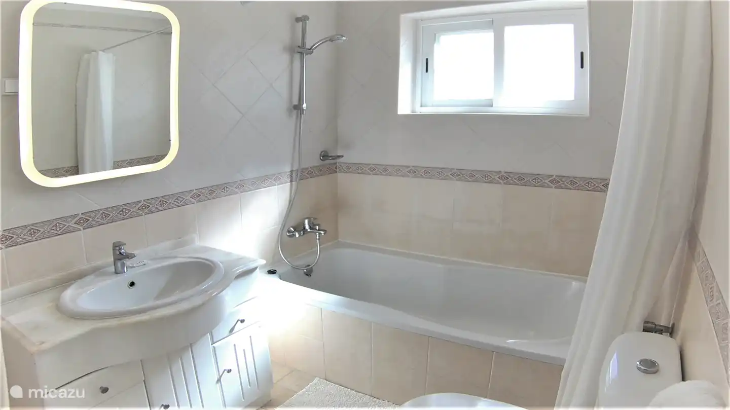 La deuxième salle de bain a une baignoire, un lavabo et des toilettes