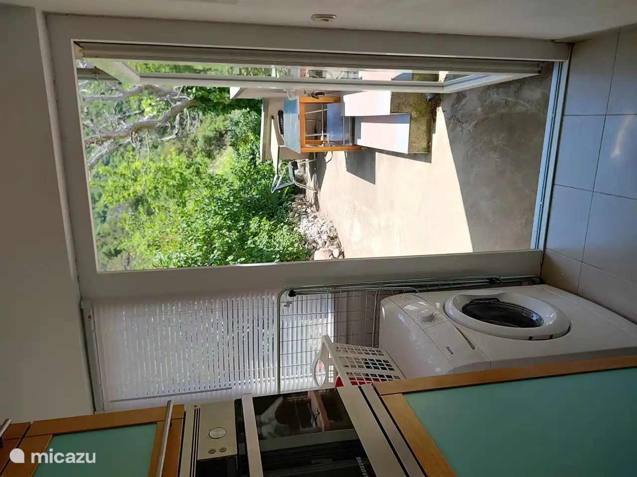 Blick von der Küche auf den Grill und die Terrasse