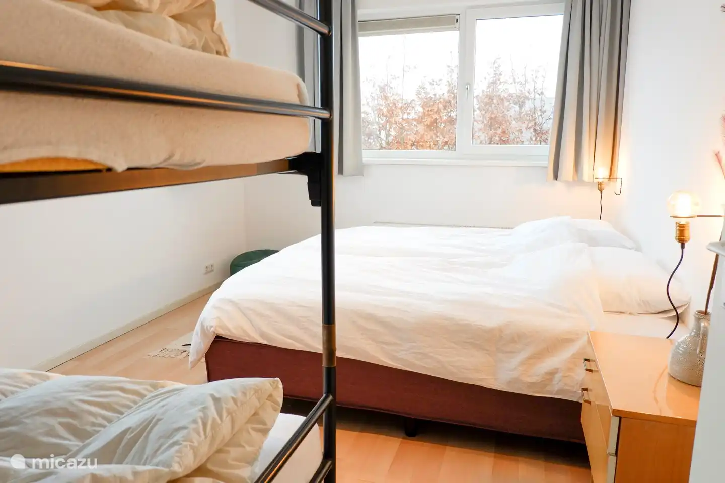 Gemütliches Familienzimmer mit 2 separaten Boxspringbetten, die zusammen- oder auseinandergeschoben werden können, mit einem Etagenbett daneben.