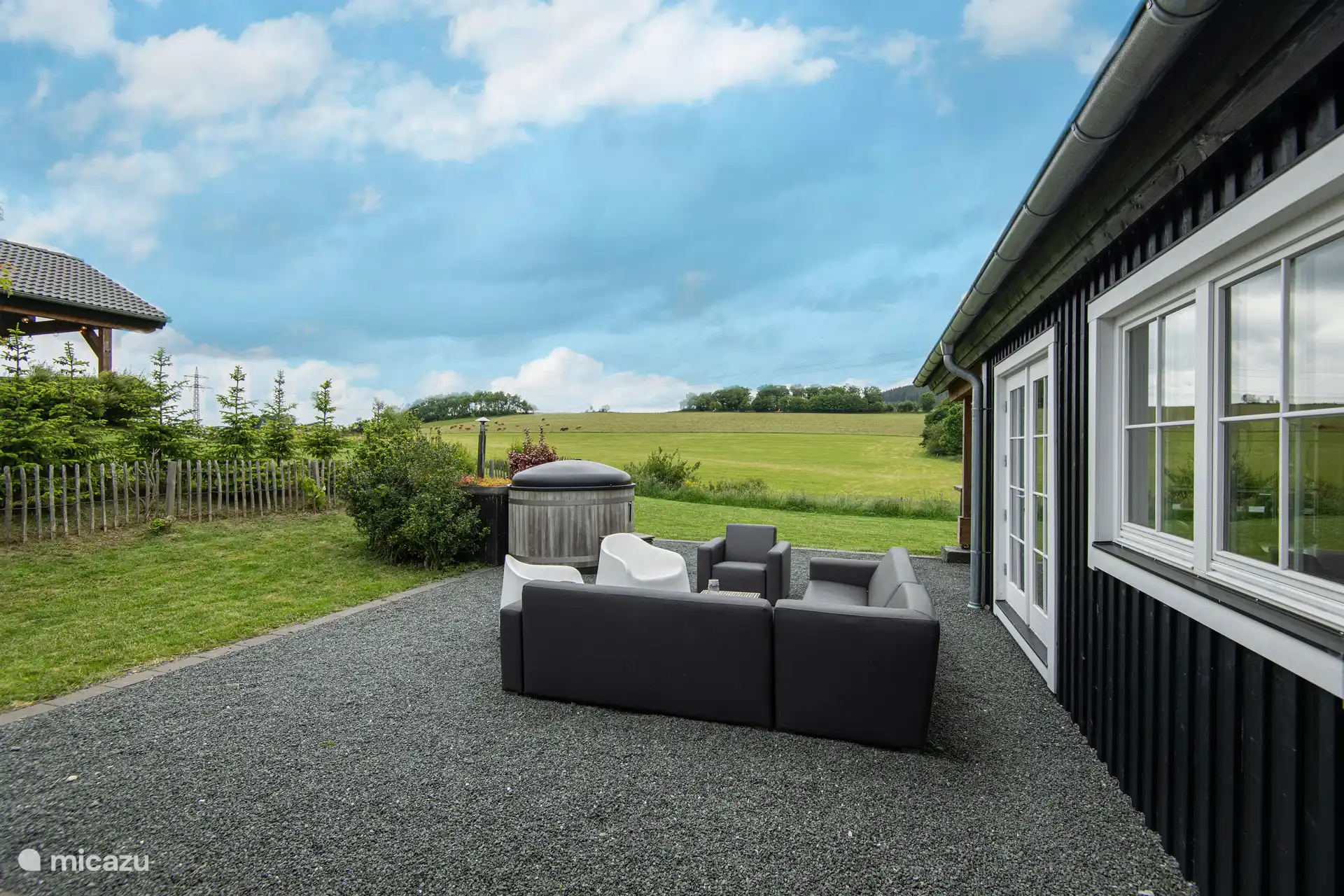 Wunderschönes Sofa mit Stühlen, die nicht vom Wind stehen, auf der Terrasse neben der Lodge 