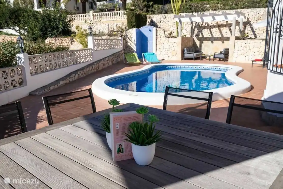 Grande terrasse avec piscine privée, douche extérieure, salon et table à manger avec 8 chaises avec vue sur la mer et parasol