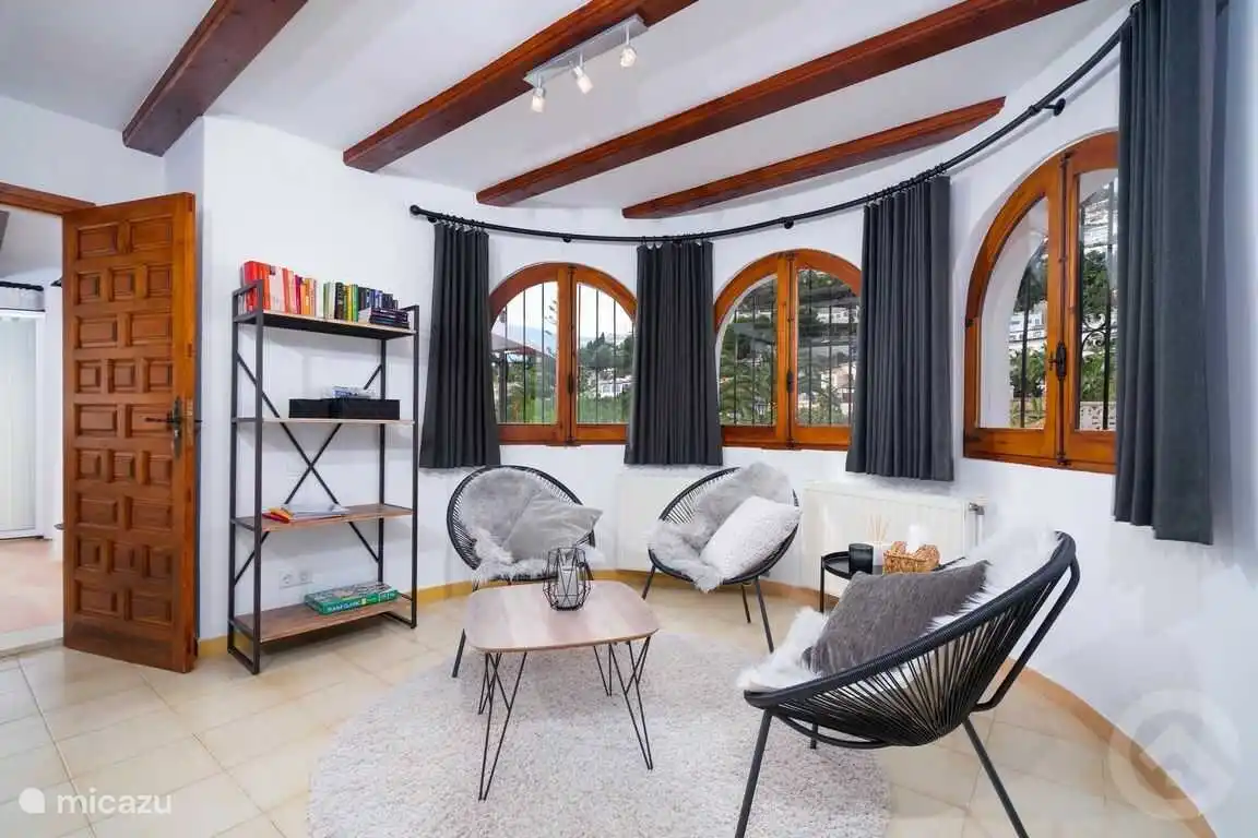 Le coin lecture dans le salon avec accès à la véranda puis à la terrasse de la piscine