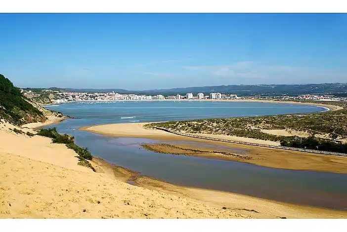 Der gleiche Blick auf die Bucht, aber jetzt von der Düne von Salir do Porto aus. Vorne und in der Mitte sehen Sie die ruhigen Strände von Salir. Es gibt auch einen Strand rund um die gesamte Bucht, an dem Sie spielen und gesund werden können. Die Gezeiten in der Bucht sind sehr ruhig, was es für Kinder sehr sicher macht.