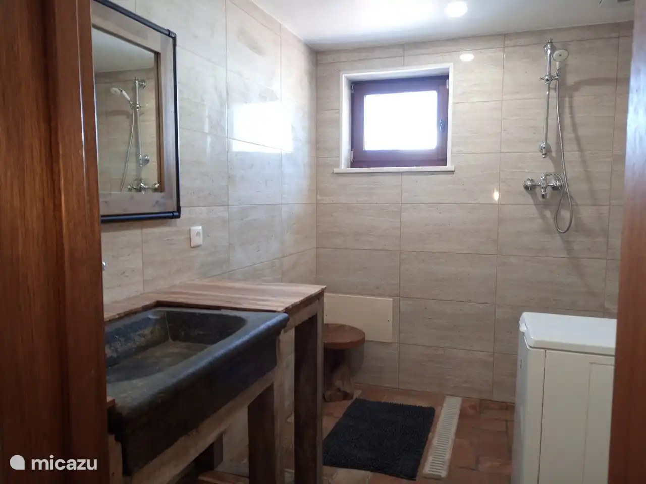 Badezimmer mit Waschtisch, Dusche, WC und Waschmaschine. E-Heizung, Föhn.