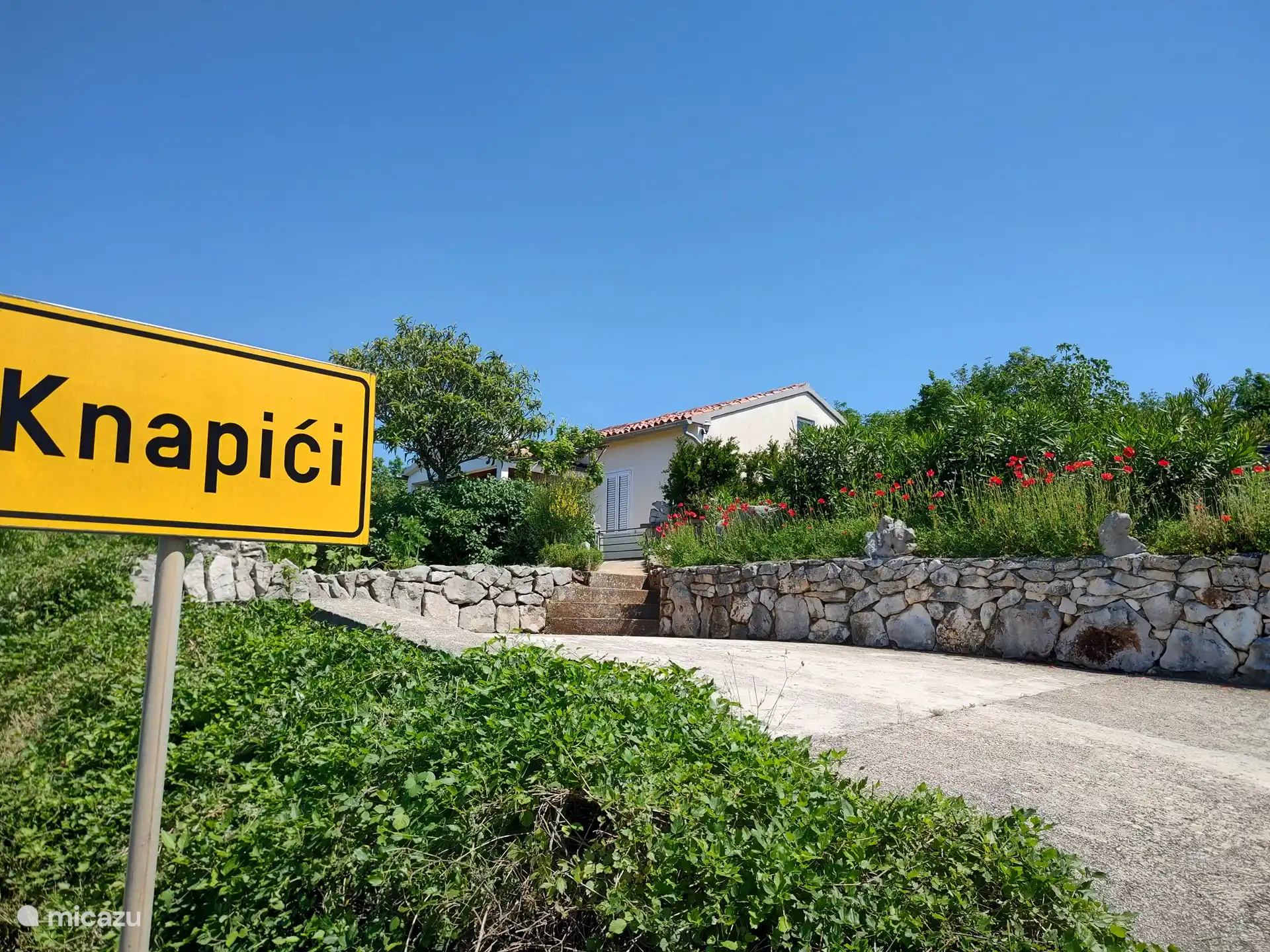 La maison est entourée d'un jardin méditerranéen ensoleillé et d'un grand parking pour deux voitures.