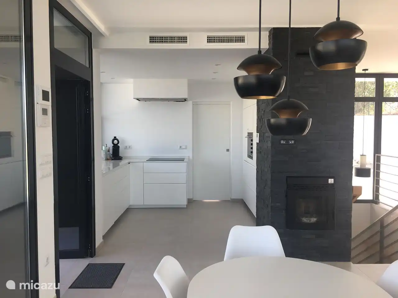 cuisine ouverte avec fenêtre guillotine et poêle à granulés dans le salon