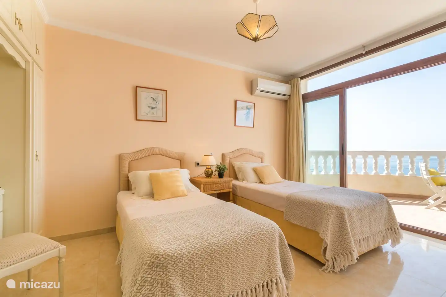 Slaapkamer met twee aparte bedden en terras