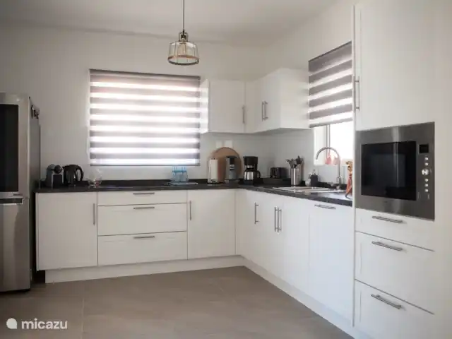 Bunita Blenchi huren in Curaçao, Banda Abou (west), Fontein - villa De zeer ruime keuken met veel bergruimte. Deze is van alle gemakken voorzien: vaatwasmachine, combi magnetron, keramische kookplaat en grote dubbele koel/vriescombinatie met koud water tap en ijsblokjes machine. Een tosti apparaat, Senseo, Nespresso en ook koffie zet apparaat zijn aanwezig