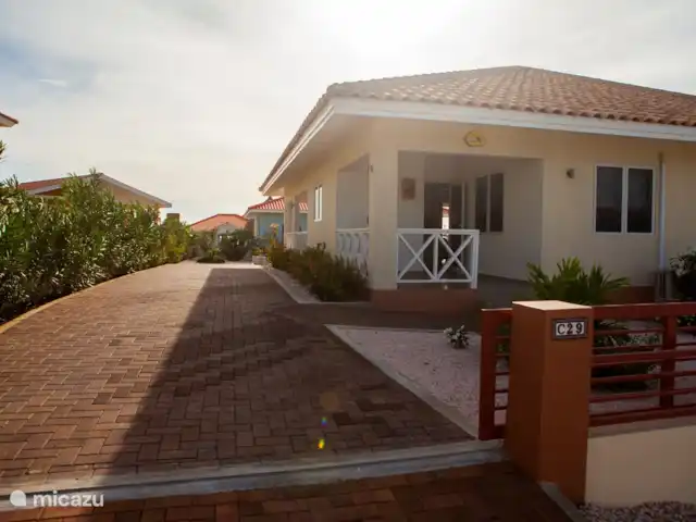 Bunita Blenchi huren in Curaçao, Banda Abou (west), Fontein - villa De voorzijde van de woning met de grote oprit. Hier kunt u makkelijk 2 autos parkeren. Daarnaast kan de oprit met een schuifpoort worden afgesloten