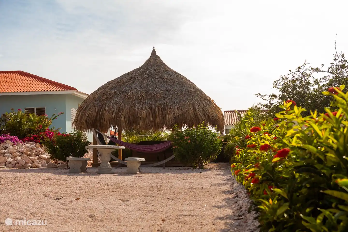 La Palapa con el salón ambientado en el jardín con muchas plantas.