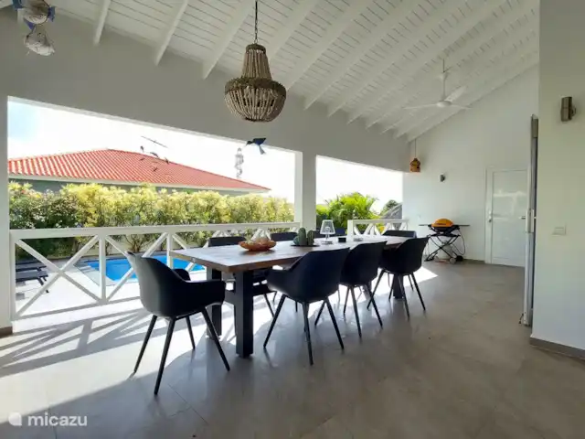 Bunita Blenchi huren in Curaçao, Banda Abou (west), Fontein - villa De dinning set op de porch. De set bestaat uit 8 comfortable stoelen en een teak  tafel van 3x1m. Het is hier lekker ontbijten, lunchen en dineren. In Curacao leeft u voornamelijk buiten, Het is lekker vertoeven op de hoek porch van 42m2. Voor verkoeling heeft de porch 2 plafond ventilatoren