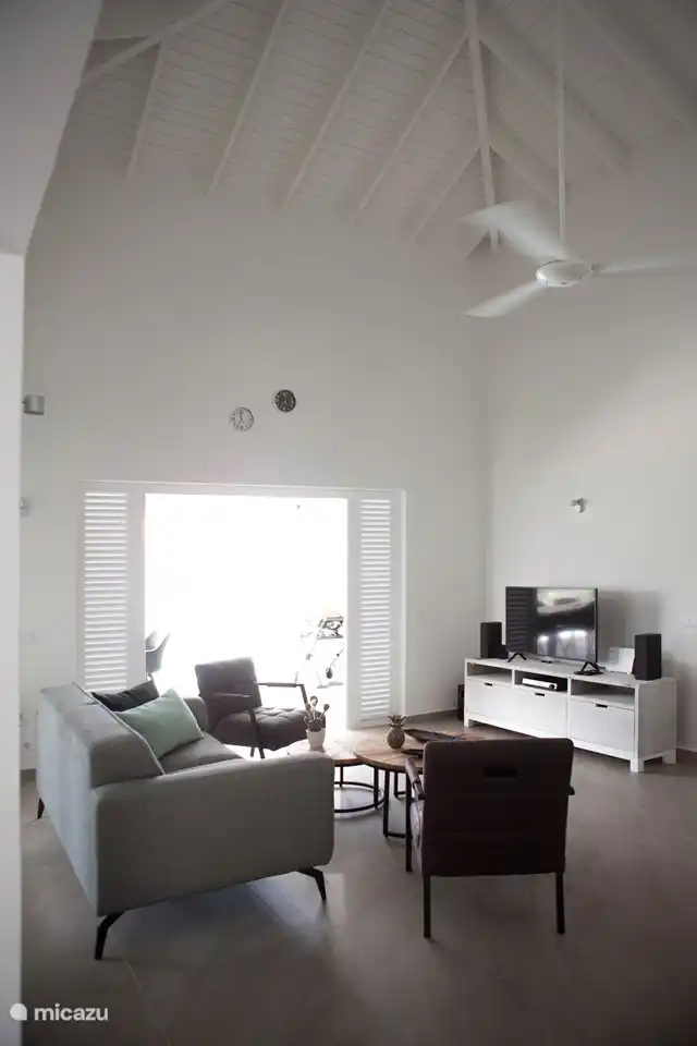 El salón tiene un sofá y 2 sillones relax. Además, por supuesto, un mueble de televisión con TV y DVD de cine en casa. Puedes escuchar música a través de las 2 cajas de Sonos. Para más equipamiento hay un aparador y librería. El ventilador de techo proporciona refrigeración.