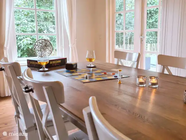 Location de Vacances Pays-Bas, Gueldre, Hulshorst (lac Veluwe), villa - Vacances de rêve Veluwe Beau salon avec portes-fenêtres donnant sur le jardin et une grande table de 2,20 m avec 6 chaises. Idéal pour jouer à un jeu!
