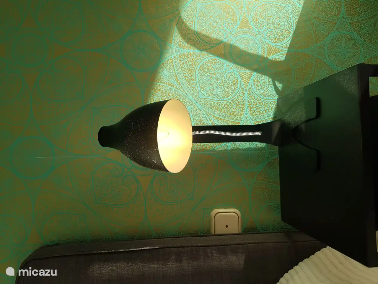 Mesita de noche con l&#225;mpara de noche y cargador de tel&#233;fono inal&#225;mbrico.