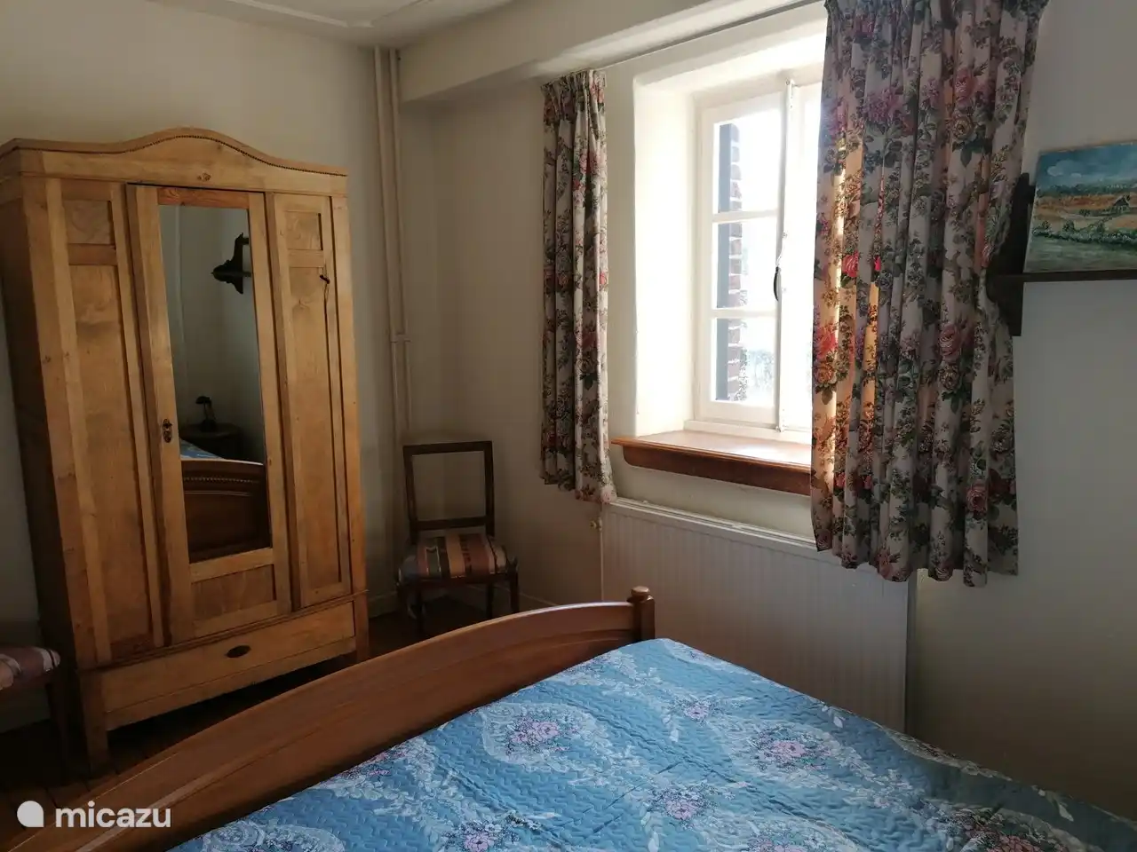 Kast met spiegel, legplank en hangers. Raam kijkt uit op ...