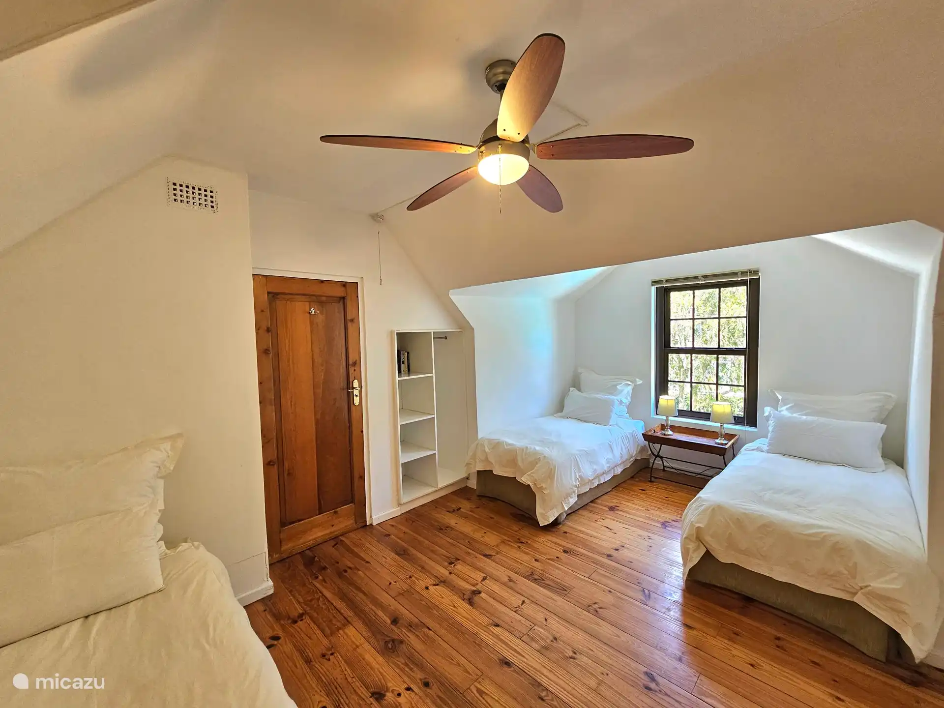 Slaapkamer met drie single bedden op eerste etage van de cottage