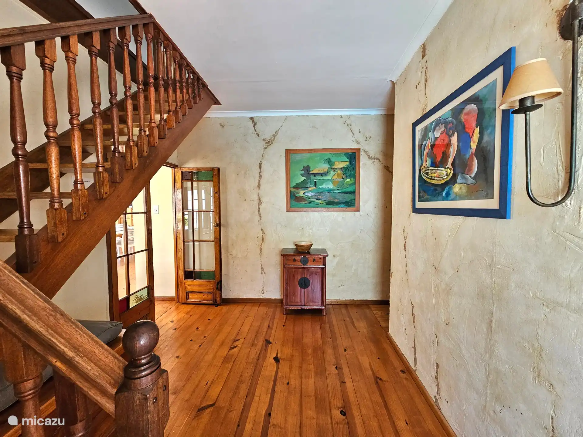 Hal binnenkomst naar lounge en trap naar eerste etage hoofdslaapkamer en aangrenzende badkamer