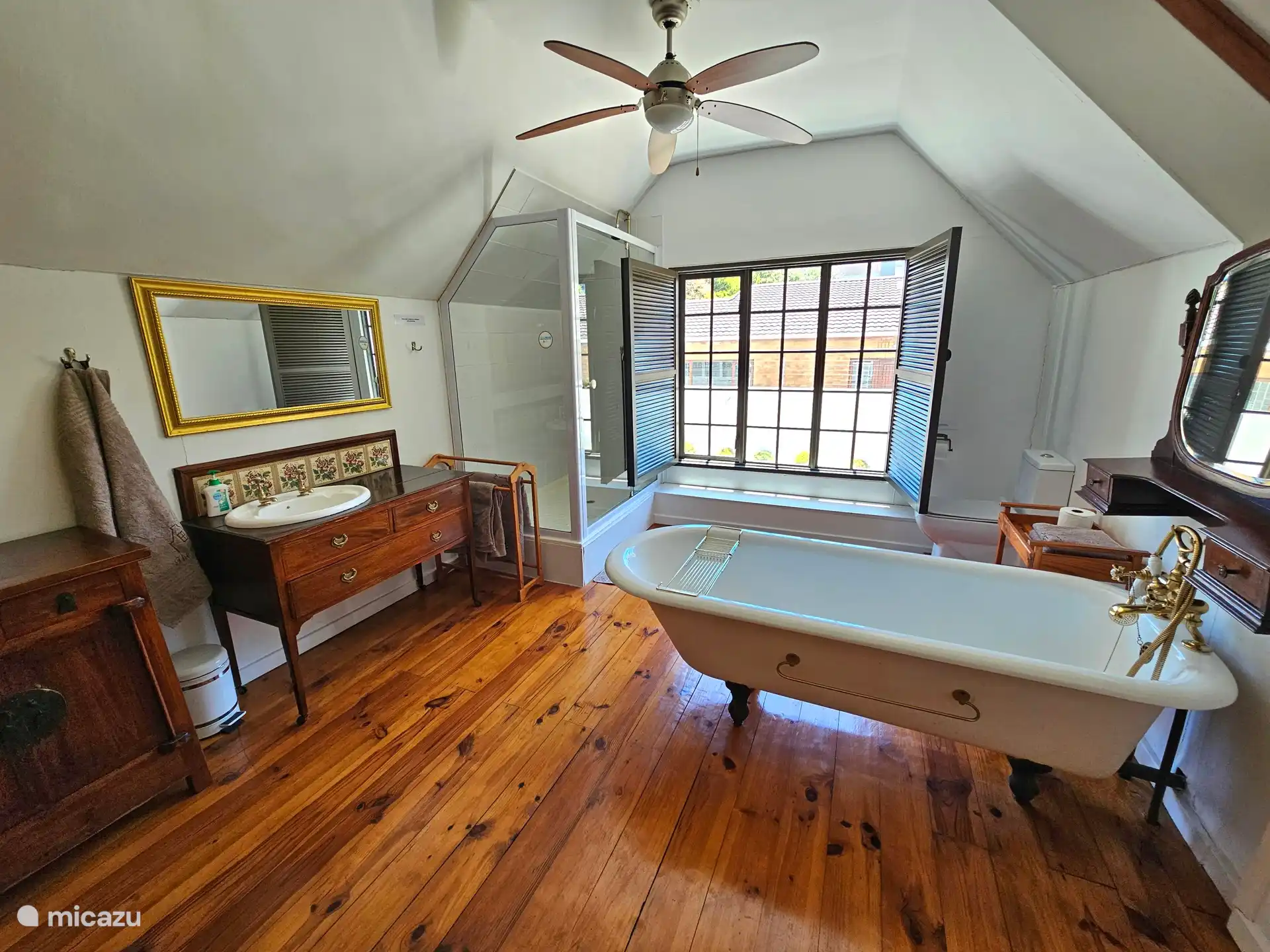 Badkamer bij de hoofdslaapkamer met bad, douche, wastafel en toilet