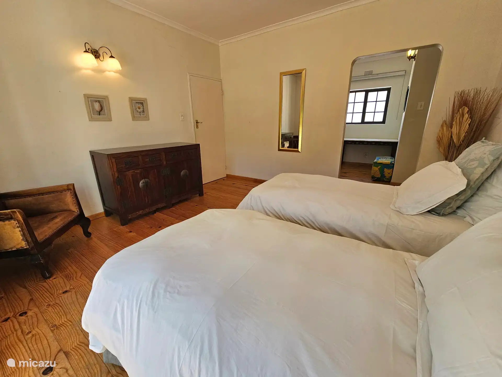 Slaapkamer met twee single bedden, op de begane grond en een naastgelegen ruimte met buro en kinderbedje