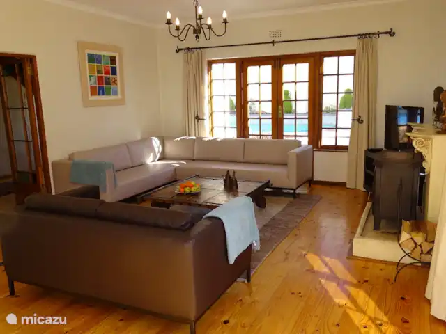 Location de Vacances Afrique du Sud, Le Cap (Cap occidental), Houtbaai, villa - The Gables, Hout Bay Coin salon avec canapés lounge en cuir, poêle à bois et TV