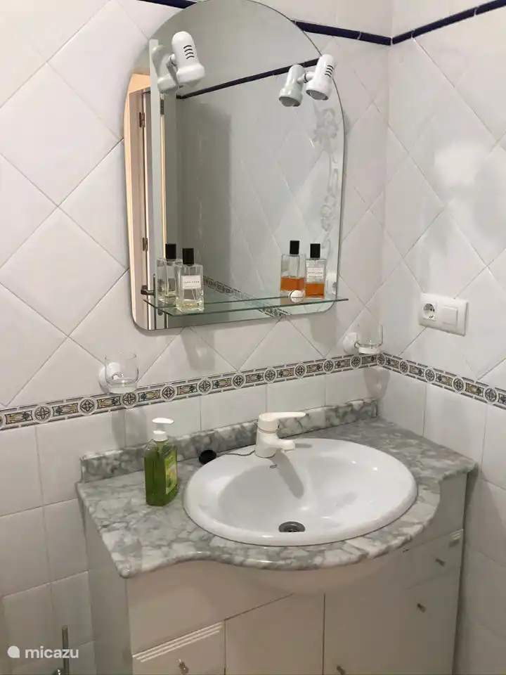 Ruime badkamer met grote handdoeken om af te drogen.