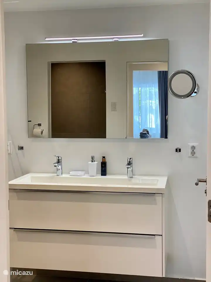 Master bathroom adjacent with enclosed space with washer and dryer