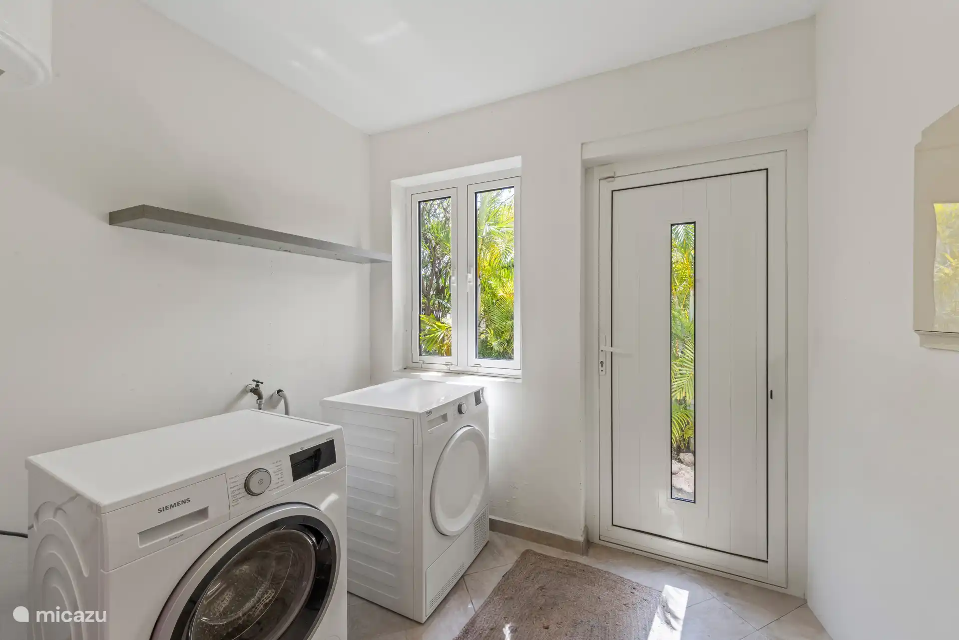 Buanderie, avec machine à laver, sèche-linge, porte-linge, planche à repasser et fer à repasser.