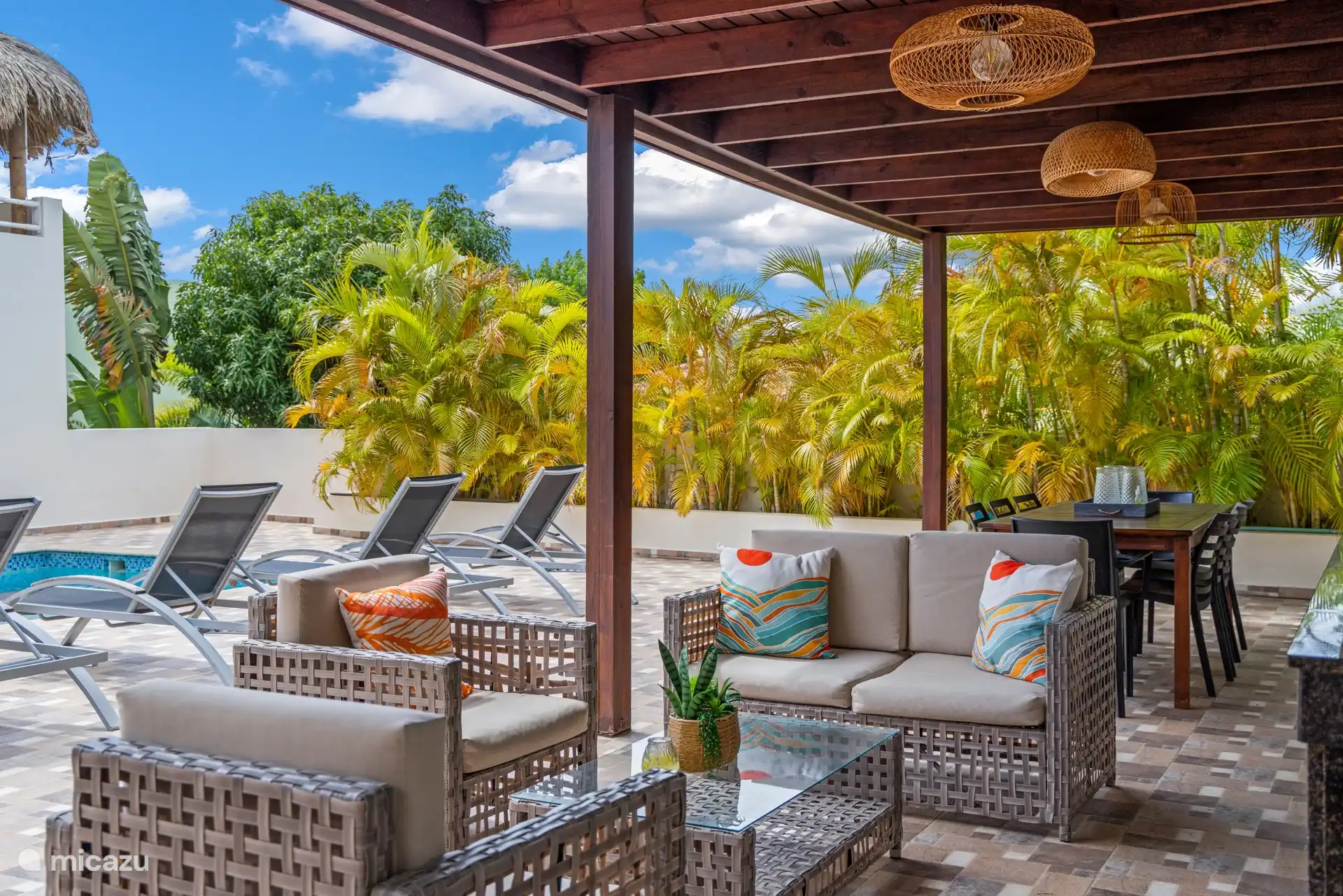 Une terrasse couverte avec salle à manger et cuisine extérieure — idéale pour les repas en plein air.