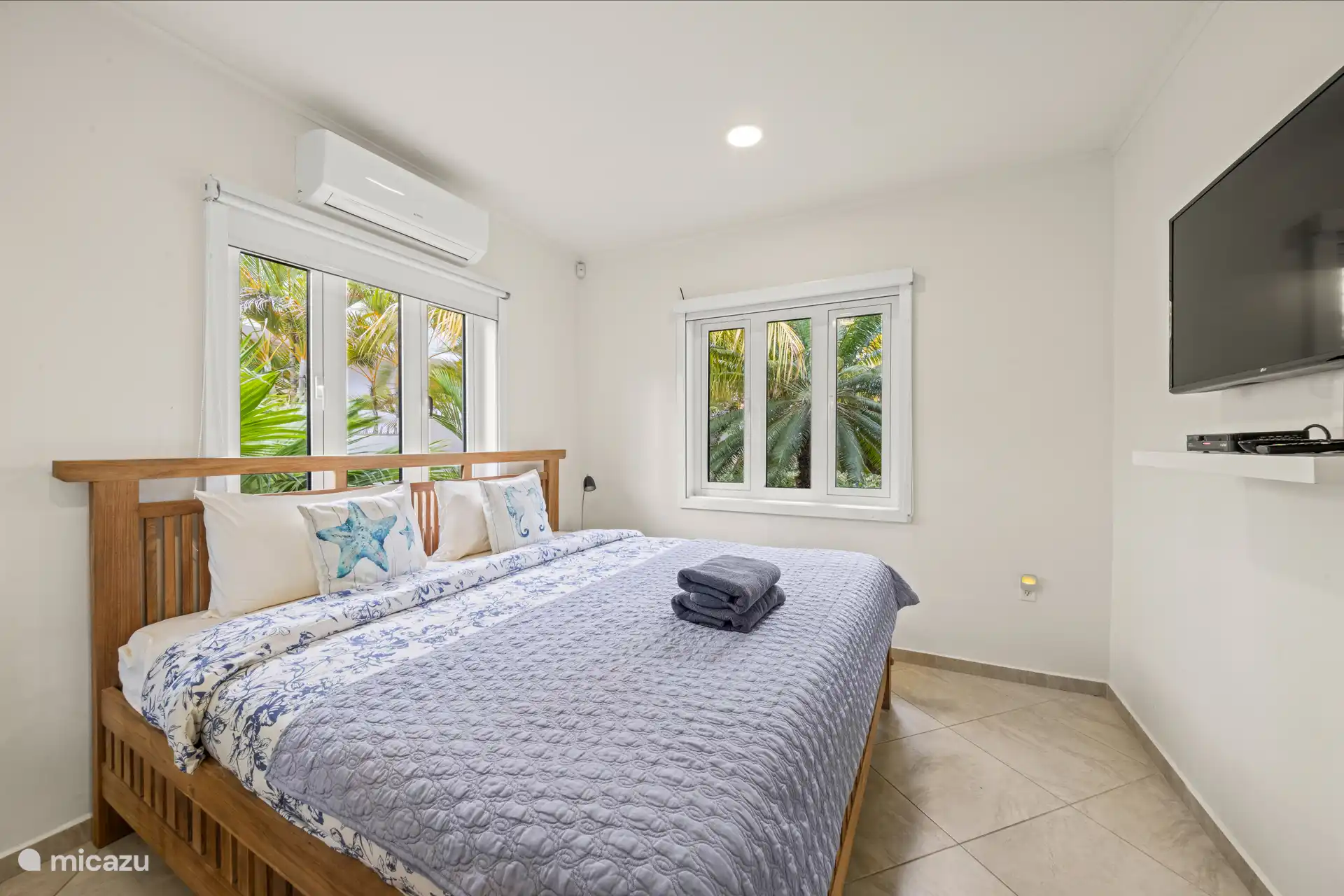 Deuxième chambre avec climatisation, espace de rangement et télévision.