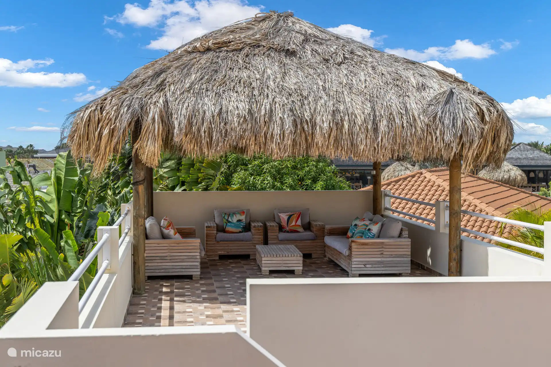 Une terrasse surélevée séparée avec un palapa ombragé offre une vue panoramique sur la piscine, l’océan et l’île environnante.