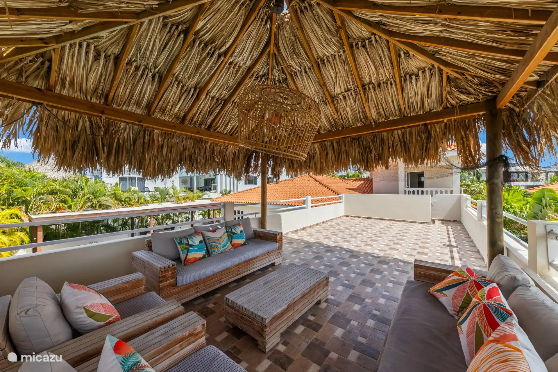 Une terrasse surélevée séparée avec un palapa ombragé offre une vue panoramique sur la piscine, l’océan et l’île environnante.