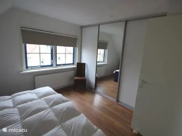 feliz en holanda en Países Bajos, Holanda del Norte, Schoorl - casa vacacional La habitación del frente tiene un amplio armario con parte para colgar y estantes.