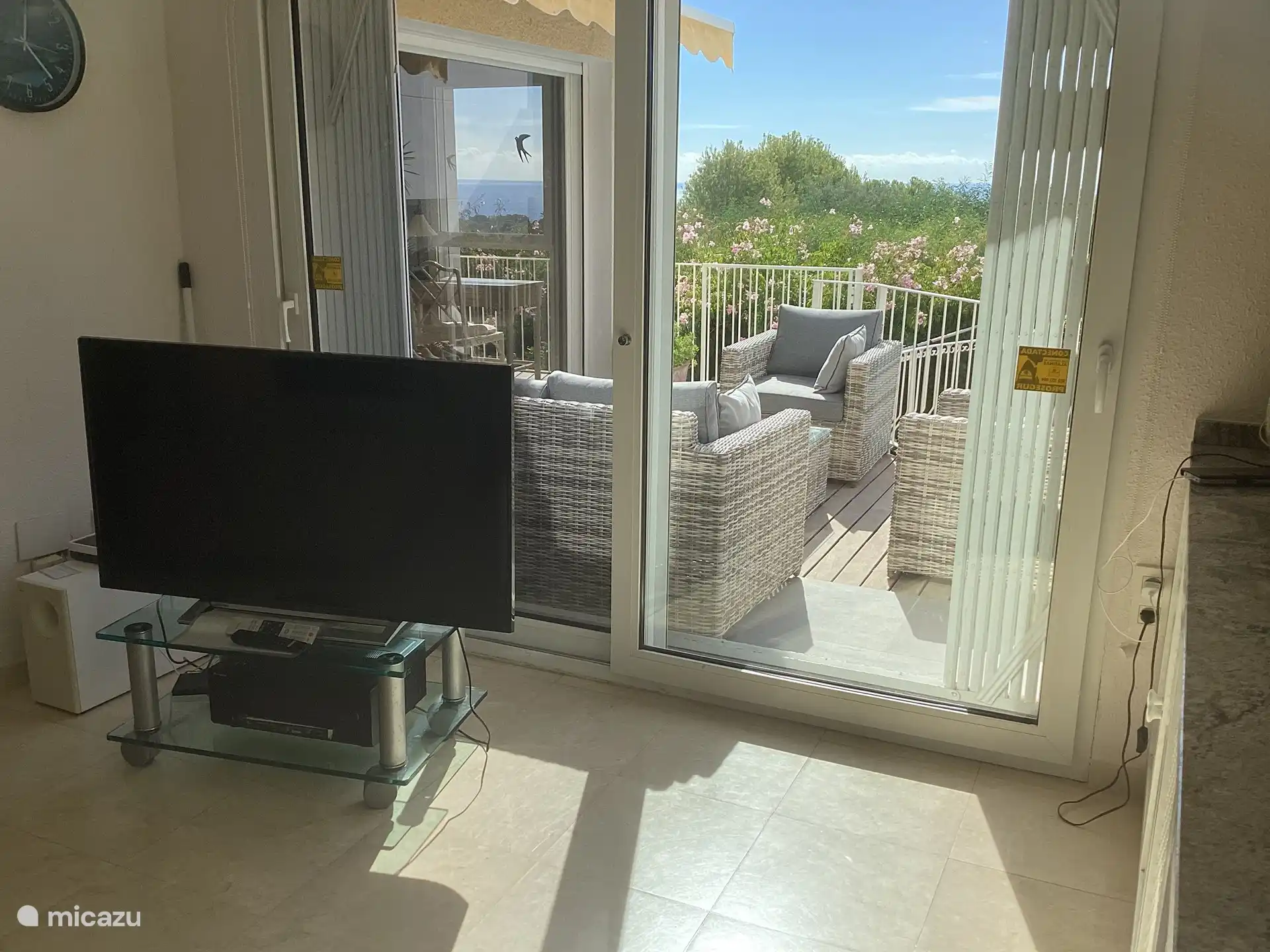 Schiebefenster zur Terrasse mit Lounge-Set.