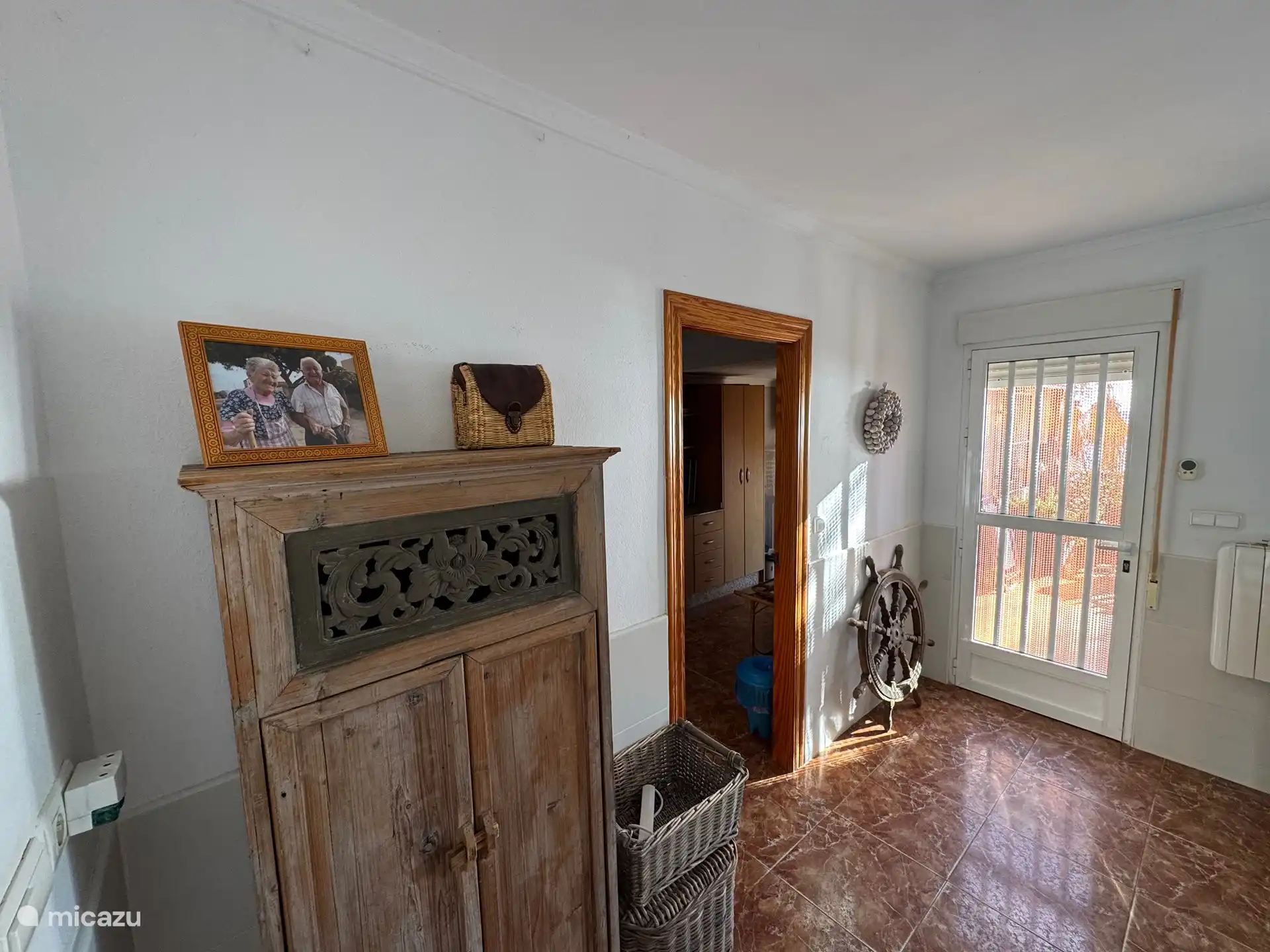 Depuis le salon, vous avez accès à votre terrasse privée sur/sur la plage. La porte sur la gauche donne accès à la cuisine. Décor attrayant de style espagnol.
