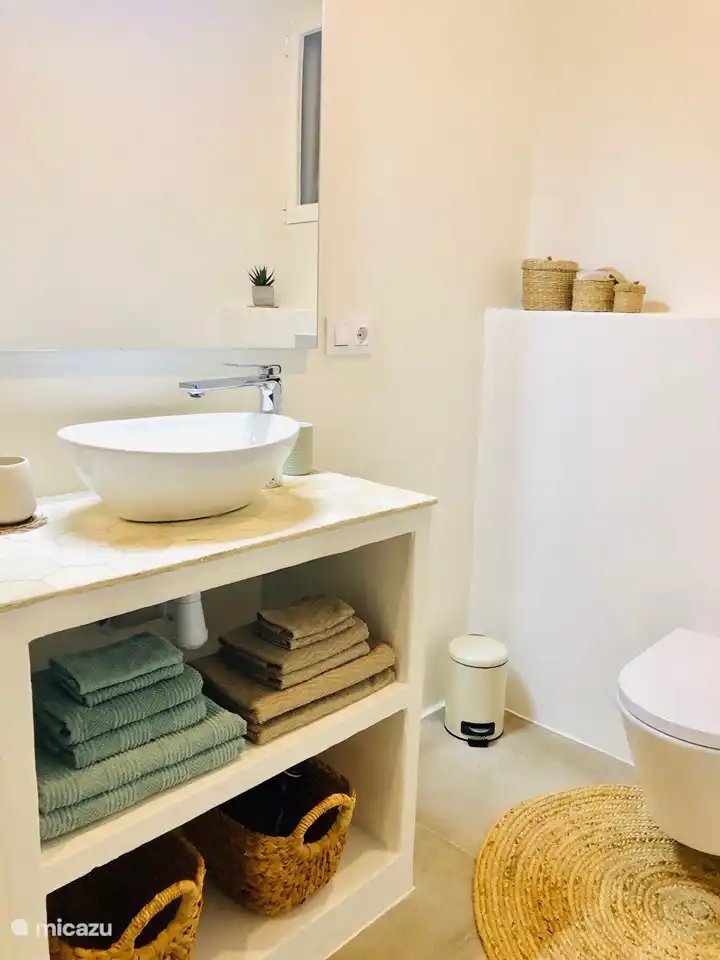 La salle de bain attenante de la chambre 3 dispose d'une spacieuse douche à l'italienne, vasque avec grand miroir, toilettes, rangements suffisants, ventilation, sèche-serviettes...