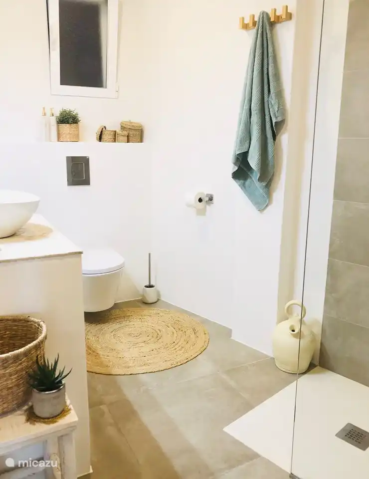 La salle de bain attenante de la chambre 3 dispose d'une spacieuse douche à l'italienne, vasque avec grand miroir, toilettes, rangements suffisants, ventilation, sèche-serviettes...