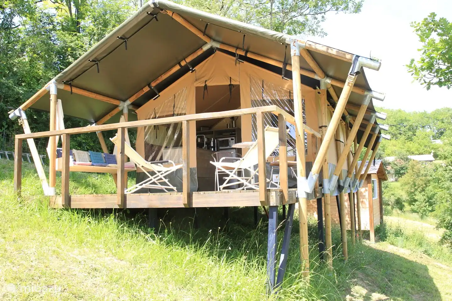 Panorama 1 Here you can see that the tent is up against the hill. The balustrade has recently been fitted with tension cables with nets to increase safety. The entrance has a door so that the terrace can be closed completely.