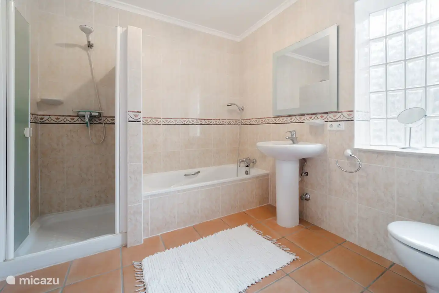 Een grote badkamer en-suite met bad, douche, toilet, bidet en wasmeubel.